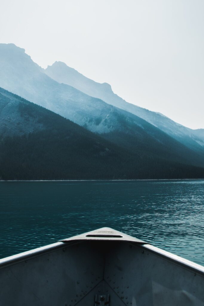 Boat tip floating on rippling lake in mountainous terrain