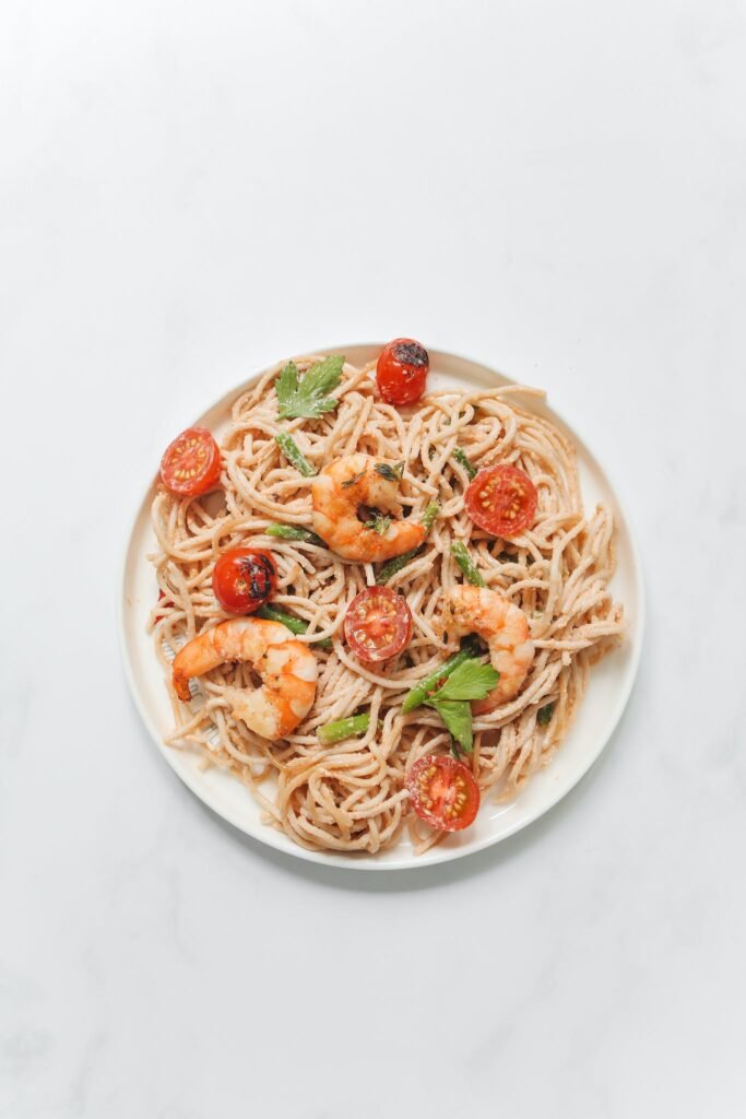 Pasta With Tomato and Shrimp on a White Ceramic Plate